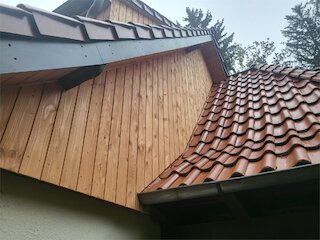 Neue senkrechte Holzverkleidung am Giebel mit fachgerechtem Anschluss an das Ziegeldach